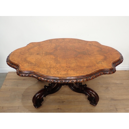 435 - A Victorian style walnut Centre Table with shaped oval top on four pierced and scrolled supports