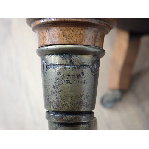 368 - A Victorian Tub Chair by Howard & Sons with button back upholstery mounted upon turned walnut front ... 