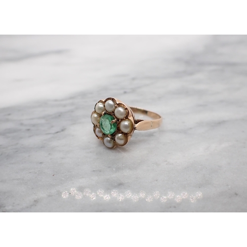 101 - An Emerald and Cultured Pearl Cluster Ring claw-set round emerald within a frame of pearls in rose g... 