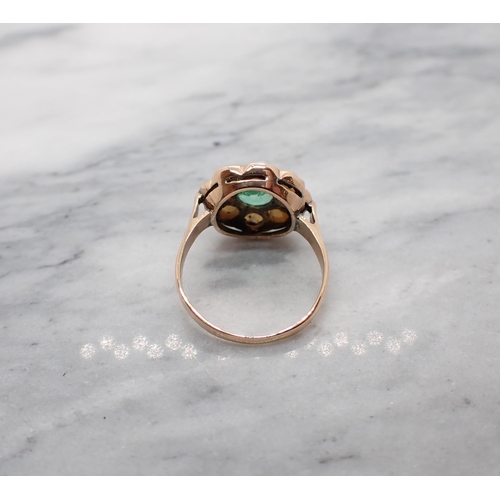 101 - An Emerald and Cultured Pearl Cluster Ring claw-set round emerald within a frame of pearls in rose g... 