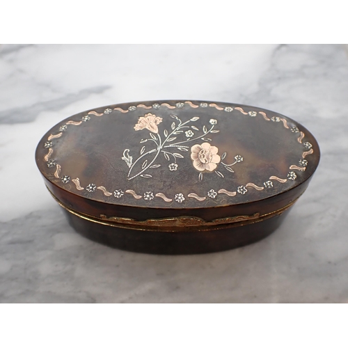 131 - A19th Century oval tortoiseshell Snuff Box the lid inlaid flowers with yellow metal mounts, 3 1/2in