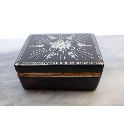 133 - A rectangular tortoiseshell Snuff Box the lid inlaid silver basket and cornucopia, 2 1/2in