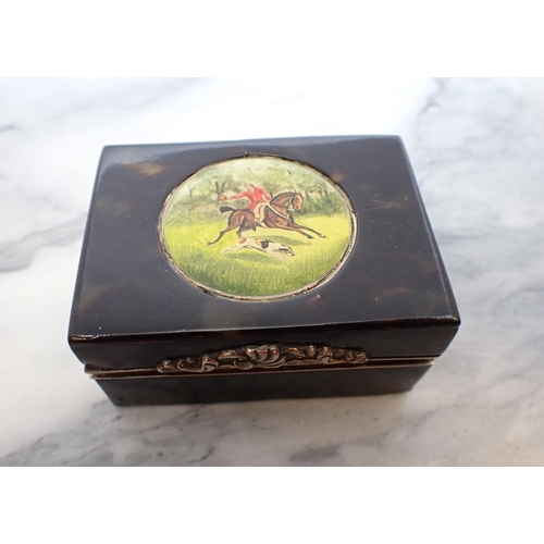 135 - A rectangular tortoiseshell Snuff Box with white metal mounts, the hinged lid with circular painted ... 