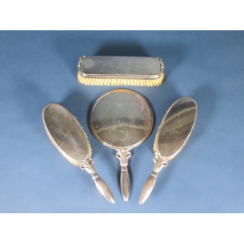 144 - A Danish silver mounted four-piece Dressing Table Set, viz: Hand Mirror, pair of Hair Brushes and Cl... 