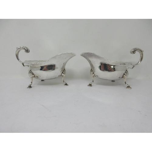 176 - A pair of Victorian silver Sauce Boats with shaped rims, leafage scroll handles on hoof feet, London... 