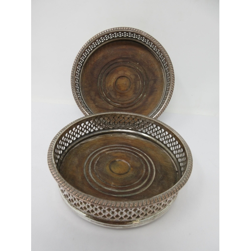 206 - A pair of plated on copper pierced circular Coasters with gadroon rims and turned wooden bases, 5½in