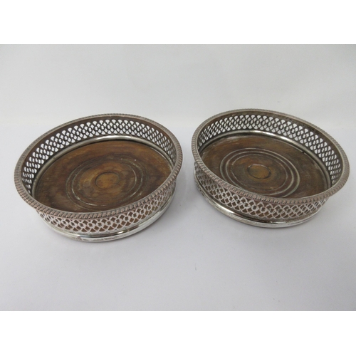 206 - A pair of plated on copper pierced circular Coasters with gadroon rims and turned wooden bases, 5½in