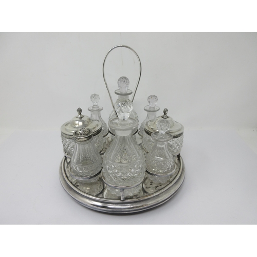 207 - A plated circular Cruet Stand with central handle fitted eight cut glass bottles and jars, two with ... 