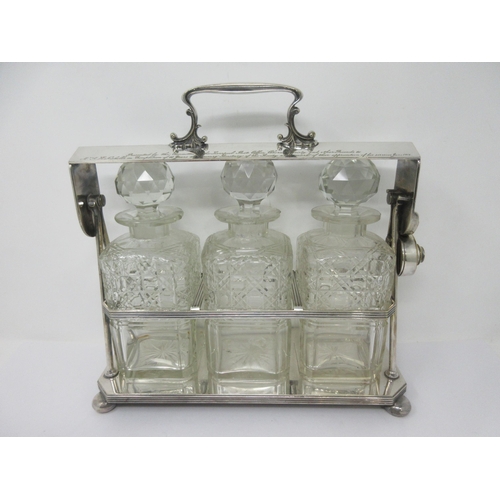 208 - A silver plated Tantalus fitted three square cut glass Decanters and Stoppers, reeded rim on ball fe... 