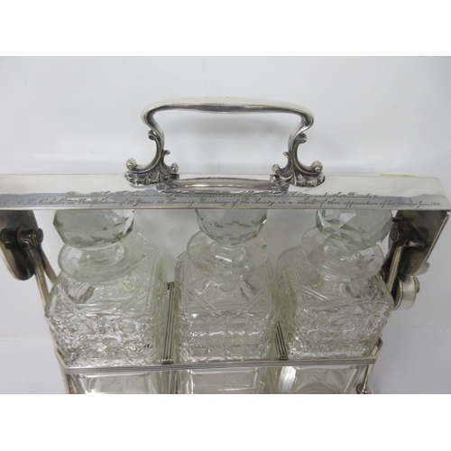 208 - A silver plated Tantalus fitted three square cut glass Decanters and Stoppers, reeded rim on ball fe... 