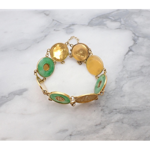 26 - A Chinese Jade Bracelet having gold discs embossed characters, three of these mounted jade circles o... 