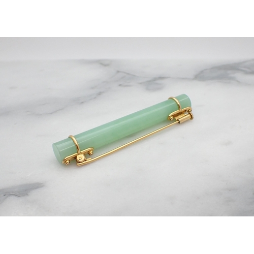 27 - A Jade Bar Brooch set simple jade baton with yellow metal mounts, approx 56mm long