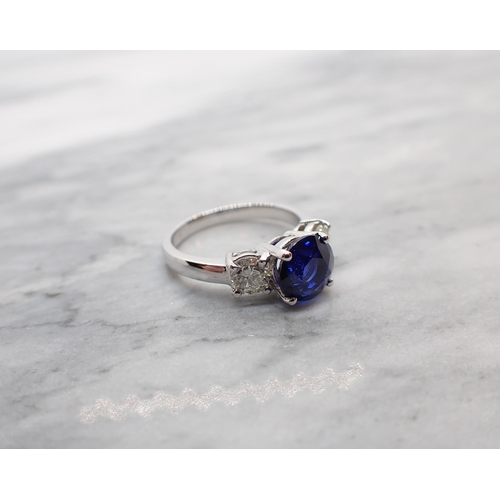 42 - A Sapphire and Diamond three stone Ring claw-set round fine sapphire, 2.65cts, between two brilliant... 