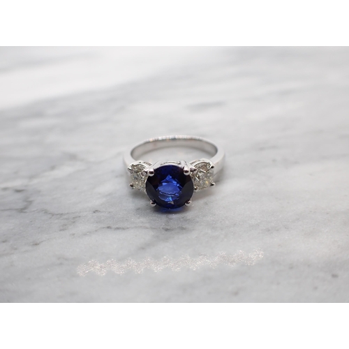 42 - A Sapphire and Diamond three stone Ring claw-set round fine sapphire, 2.65cts, between two brilliant... 