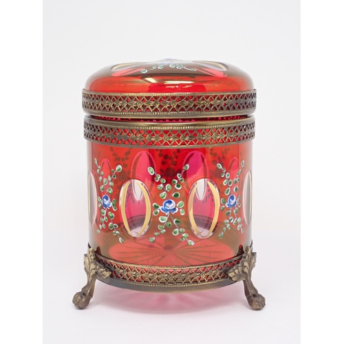 464 - A red glass Box and Cover with gilt metal mounts and cylindrical form having hinged cover and painte... 