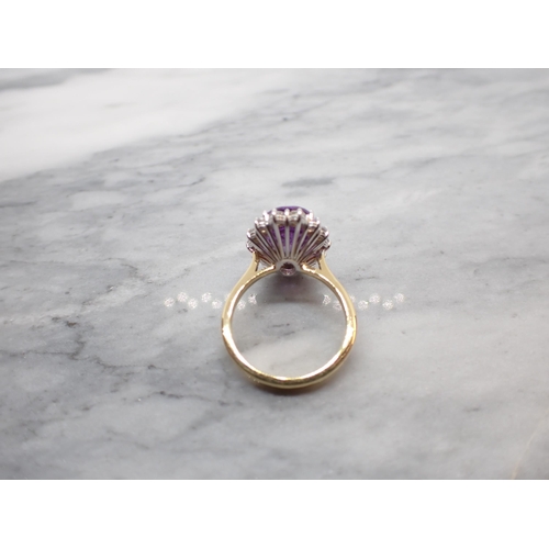 47 - An Amethyst and Diamond Cluster Ring claw-set oval-cut amethyst, 3cts, within a frame of brilliant-c... 