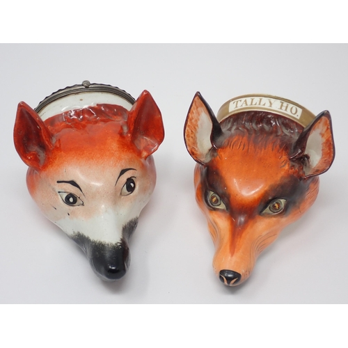 484 - Two fox mask Stirrup Cups, one titled 'Tally Ho' and another with white metal lid having embossed fl... 