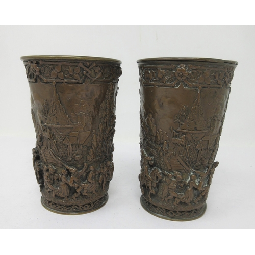 509 - A pair of bronzed Beakers of tapering form relief decorated merrymaking figures in village scene, 5¼... 