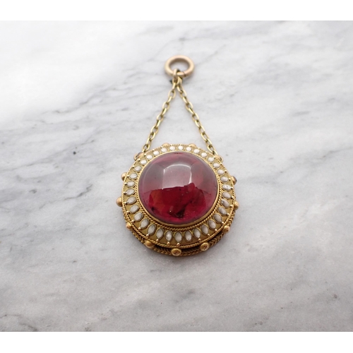 55 - A Victorian Garnet and Enamel Pendant garnet cabochon within frame with white enamel. 25mm d.