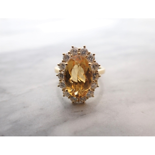 56 - A Citrine and Diamond Cluster Ring claw-set oval-cut citrine, 3cts, within a frame of fourteen brill... 