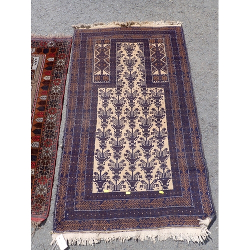 276 - A cream ground Prayer Rug with blue border 5ft L x 3ft W, another with temple design within red bord... 