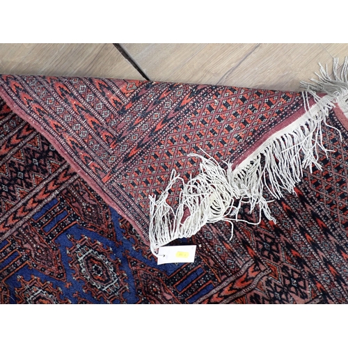 324 - A bordered Persian Rug with coloured medallions on a red ground, 5ft 11in x 3ft 3in, and a small Run... 