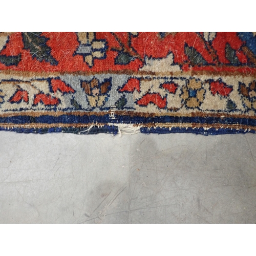 379A - A bordered Persian Rug with floral motifs on a blue ground, 6ft 6in x 4ft 5in