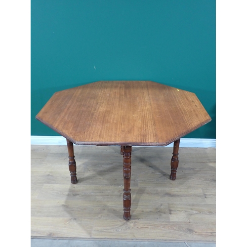 426 - An oak octagonal Dining Table mounted on turned supports 4ft W x 2ft 6in H