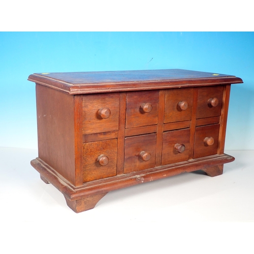 707 - A small table top Cabinet with eight drawers, 17in W x 10in H