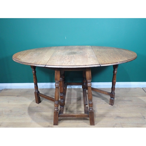 724 - An oak dropleaf table with oval top on turned supports,