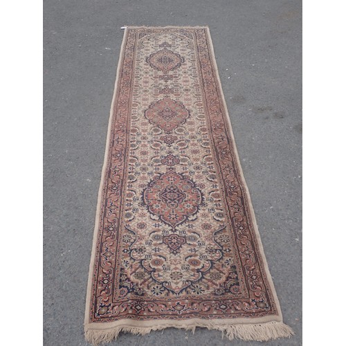 652 - A bordered Runner with oval medallions on a cream ground, 10ft 1in x 2ft 7in