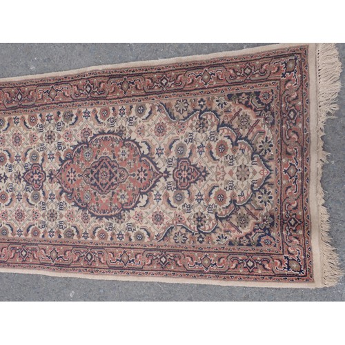 652 - A bordered Runner with oval medallions on a cream ground, 10ft 1in x 2ft 7in