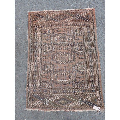 703 - A small Persian Rug, with the three medallion on a brown ground, 4ft 2in x 3ft