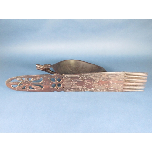 55 - A hardwood Tribal Feeding Bowl with carved mask handle, 16in, and a large Comb with incised and pier... 