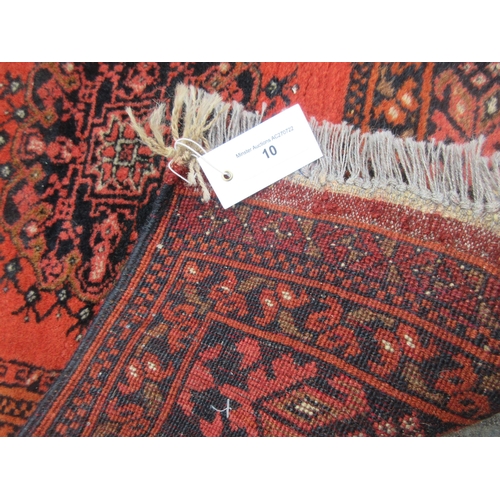 10 - A bordered Afghan Rug with eight stylised guls on a red ground, 5ft x 3ft 5in