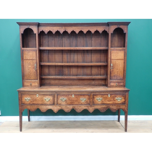 23 - A George III oak and mahogany crossbanded Dresser and rack the base fitted three drawers above shape... 