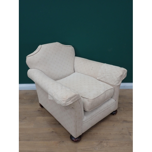 295 - An antique cream upholstered Armchair on bun feet