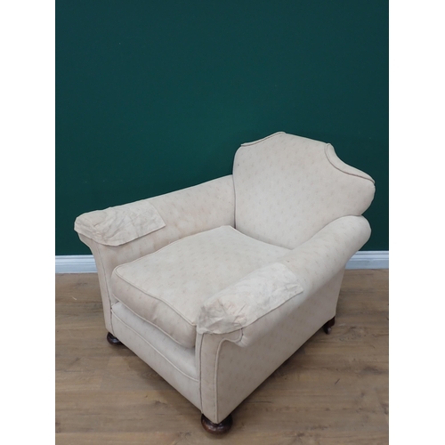 295 - An antique cream upholstered Armchair on bun feet