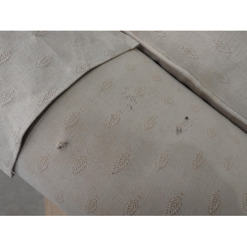 295 - An antique cream upholstered Armchair on bun feet