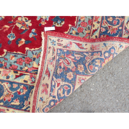 3 - An old bordered Persian Carpet with floral medallion and corner design on a red ground, the main bor... 