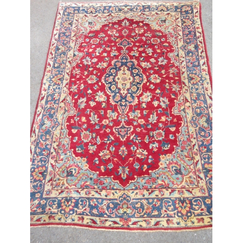 3 - An old bordered Persian Carpet with floral medallion and corner design on a red ground, the main bor... 