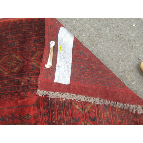 4 - A multi-bordered Afghan Carpet with geometric design on a red ground, 11ft 4in x 7ft 7in