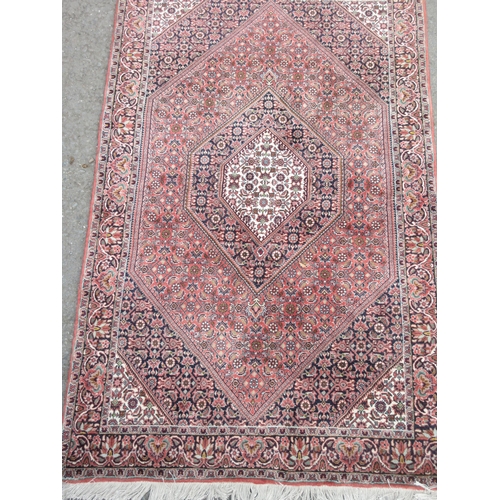 5 - A bordered Persian Rug with floral design in diamond field, 6ft x 3ft 7in