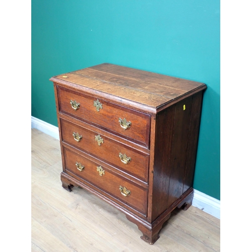 592 - A Georgian oak and mahogany crossbanded small Chest of three long drawers mounted on shaped bracket ... 