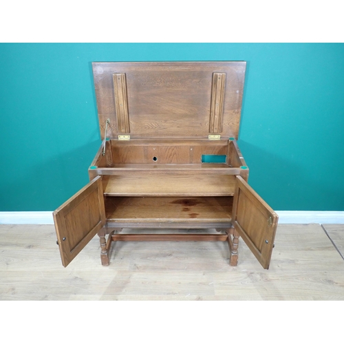 595 - A n oak linenfold panel two door Cupboard and a teak roll top Bureau