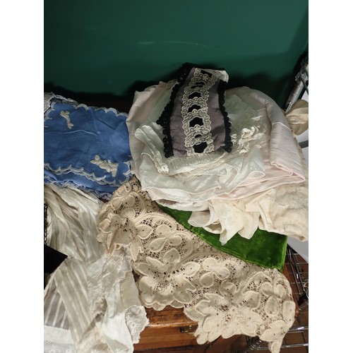 598 - A box of Victorian clothes and textiles including Petticoat, black silk Waistcoat, Curtains, Cushion... 