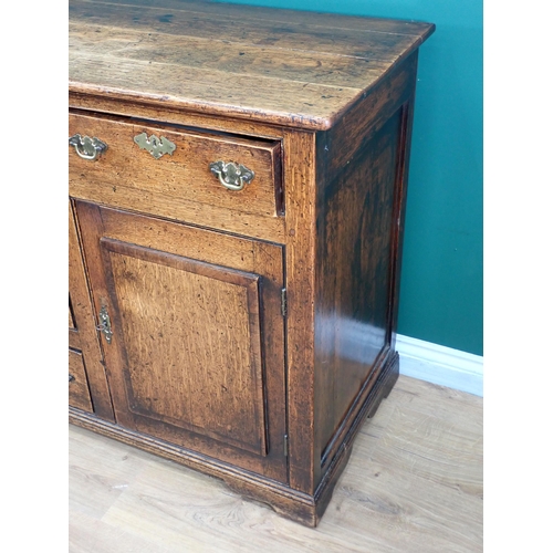 643 - An 18th Century oak and mahogany crossbanded enclosed Dresser Base fitted three frieze drawers above... 