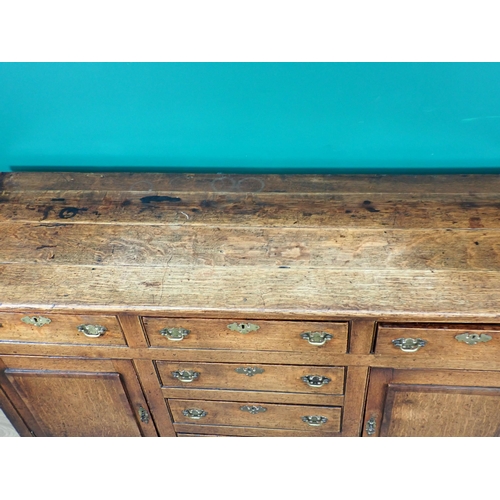 643 - An 18th Century oak and mahogany crossbanded enclosed Dresser Base fitted three frieze drawers above... 