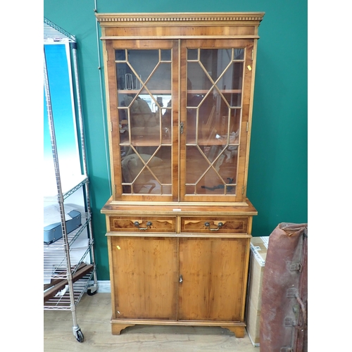 645 - A yew wood veneered and astragal glazed Bookcase above base fitted two frieze drawers and pair of cu... 