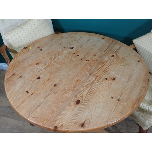 698 - A pine circular Breakfast Table and three Elbow Chairs on cabriole supports with yellow upholstery